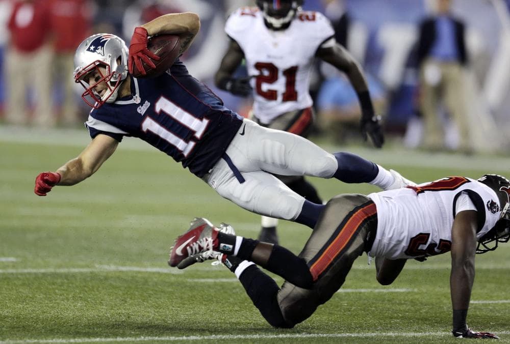 Tampa Bay Buccaneers safety Keith Tandy, right, upends New England Patriots wide receiver Julian Edelman (11) after a catch in the second quarter.(AP) 