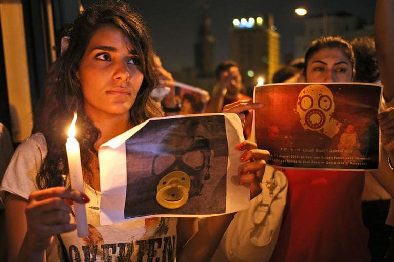 Syrian women who live in Beirut, hold candles and placards during a vigil against the alleged chemical weapons attack on the suburbs of Damascus, in front the United Nations headquarters in Beirut, Lebanon, Wednesday, Aug. 21, 2013. (AP)
