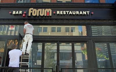 Workers paint the new sign of Forum Bar &amp; Restaurant, the site of the second blast during the Boston Marathon on April 15. (WBUR/Meghna Chakrabarti)