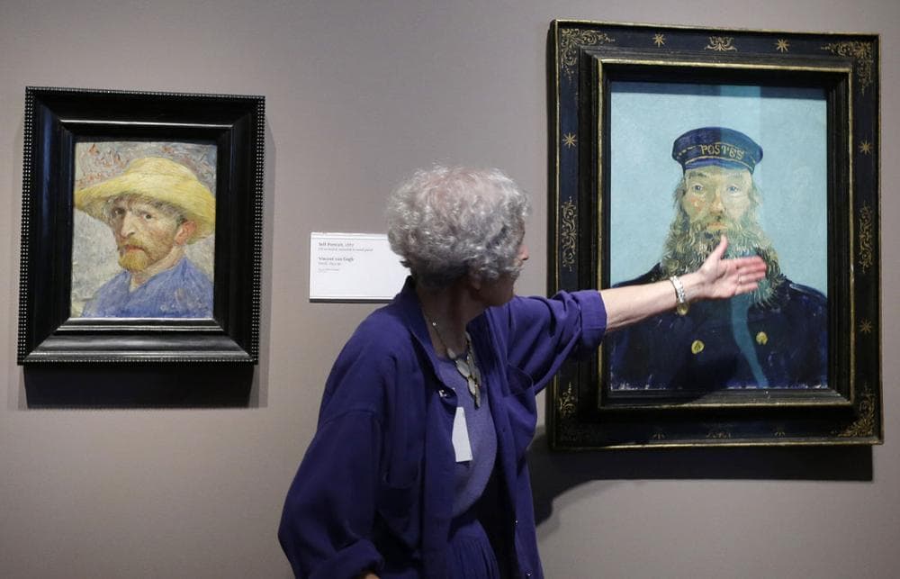 Detroit Institute of Arts docent Lea Schelke points out details in the &quot;Portrait of Postman Roulin&quot; by Van Gogh displayed at the museum in Detroit. (AP Photo/Carlos Osorio)