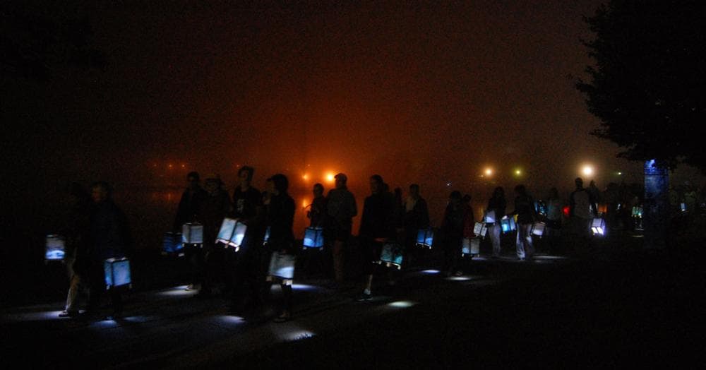 Participants carry lanterns around Pleasure Bay. (Greg Cook)