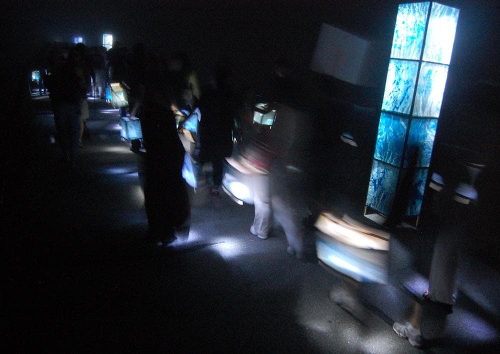 Participants carry lanterns around Pleasure Bay. (Greg Cook)