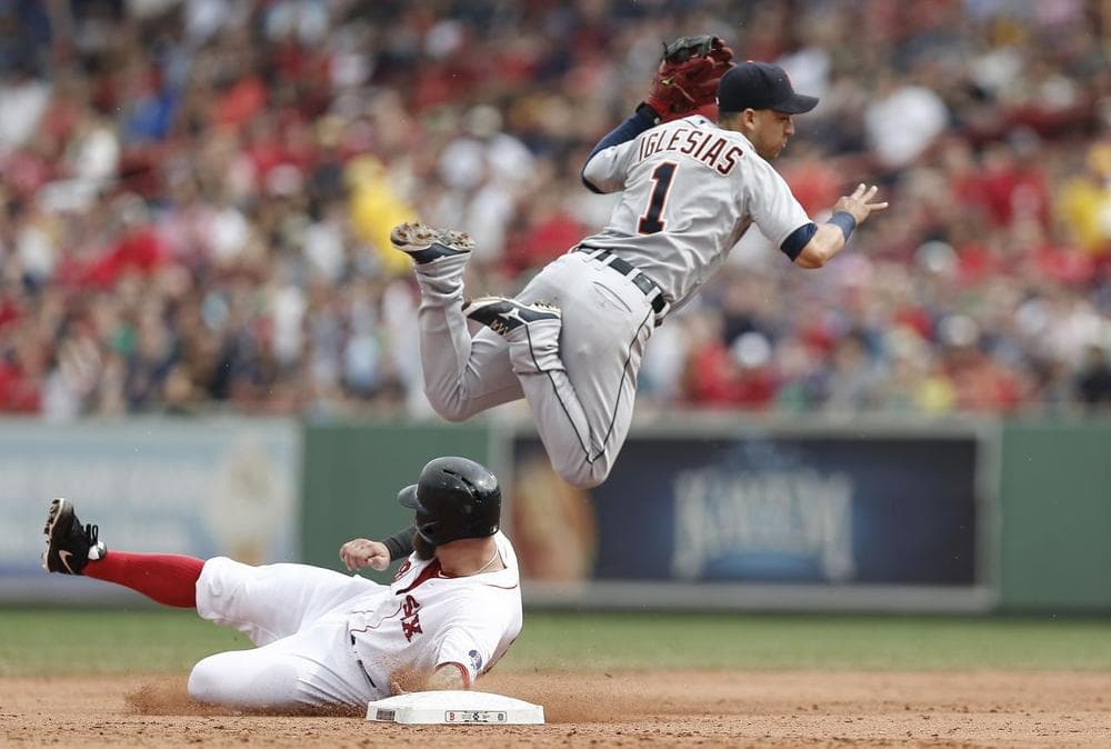 Detroit Tigers shortstop Jose Iglesias turns a double play over the slide of Boston Red Sox&#039;s Mike Napoli. (AP/Winslow Townson)