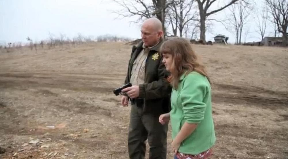 Sheriff Warren Wethington shows his visually impaired daughter how to shoot a firearm. (Screenshot from the Des Moines Register video) 