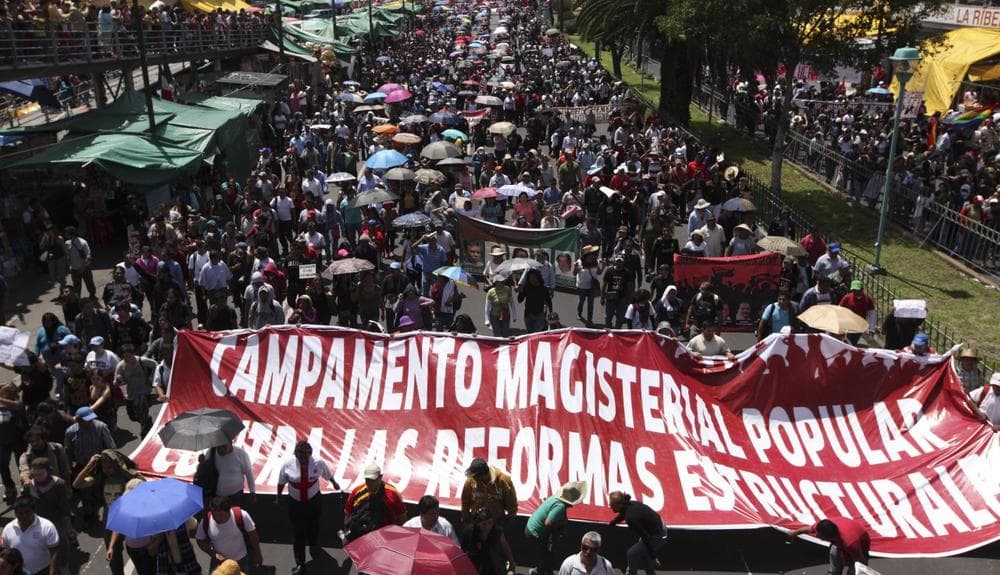 Protesters march down a street in Mexico City, Sunday, Sept. 1, 2013.  (Marco Ugarte/AP)