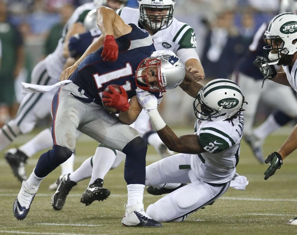 New York Jets defensive back Ellis Lankster (21) tries to tackle New England Patriots wide receiver Julian Edelman (11). (AP/Elise Amendola)