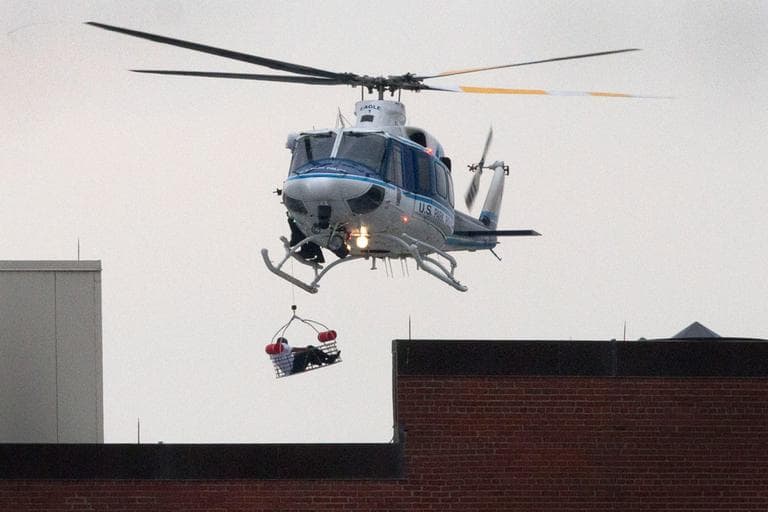 A U.S. Park Police helicopter removes a man in a basket from the Washington Navy Yard Monday. (Jacquelyn Martin/AP)