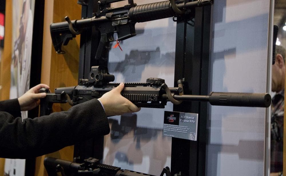 Accessories manufacturer Kevin Kao examines a military grade Remington ACR Special Purpose Rifle at a gun show in Las Vegas, January 2013. (Julie Jacobson/AP)
