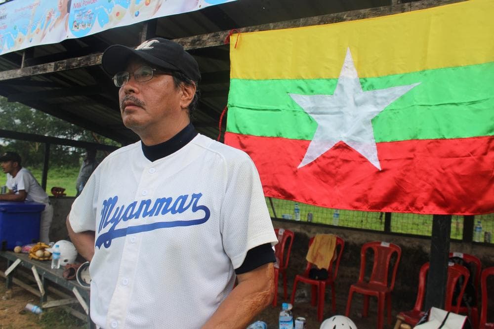 Coach Toru Iwasaki in front of the dugout with the Myanmar national flag. (David Grunebaum/Only A Game)