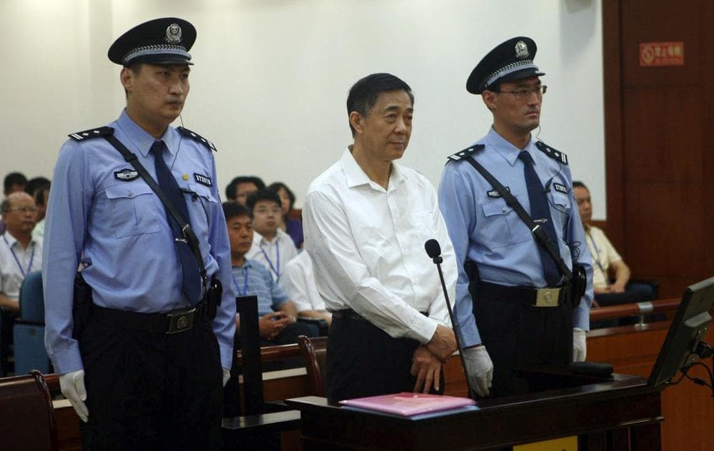 In this Aug. 22, 2013 file photo released by the Jinan Intermediate People's Court, former Politburo member and Chongqing city party leader Bo Xilai, center, stands on trial at the court in eastern China's Shandong province. A verdict is expected on Sept. 22. (Jinan Intermediate People's Court via AP)