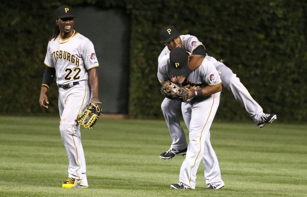 Pittsburgh Pirates center fielder Andrew McCutchen, left, Starling Marte, center and Marlon Byrd celebrate the Pirates' 2-1 win over the Chicago Cubs after a baseball game Monday, Sept. 23, 2013, in Chicago. (Charles Rex Arbogast/AP)