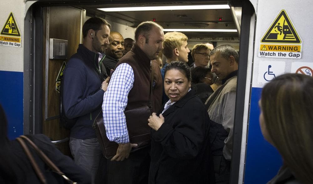 Commuters cram into the doorway of a Stamford bound train at Grand Central Terminal as transit on the New Haven line is running on limited capacity, Wednesday, Sept. 25, 2013, in New York. (John Minchillo/AP)