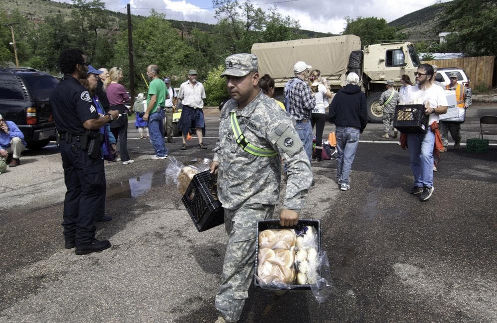 A National Guard soldier carries bread into Lyons, Colo., Sept. 13, 2013. Access to the small mountain town was cut off after bridges were destroyed by flash flooding. (Kenneth Wajda/AP)