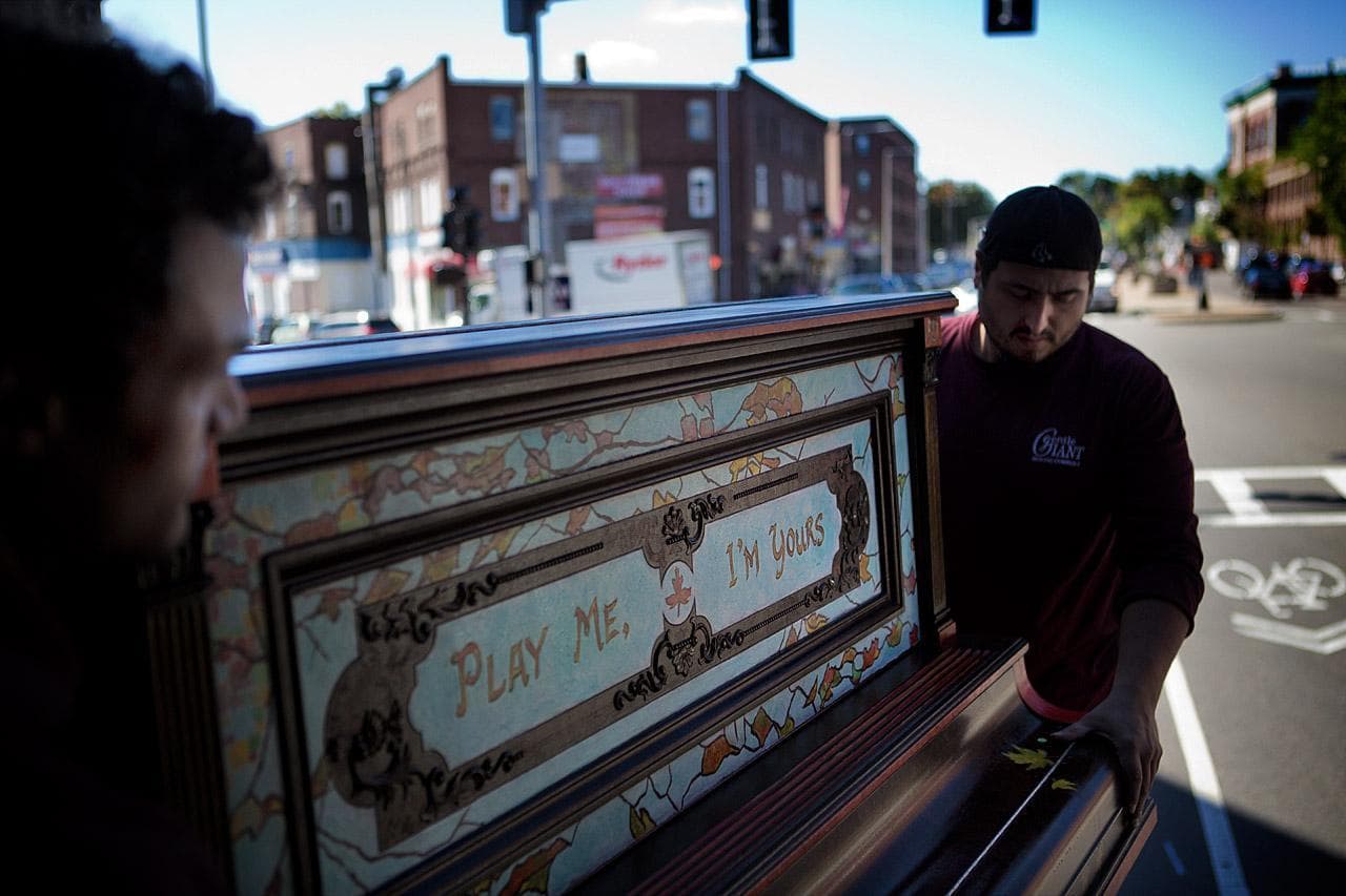 Movers lift artist Pampi’s piano from a truck for installation at the Strand Theater in Dorchester. It was inspired by American ragtime. (Jesse Costa/WBUR)Movers lift artist Pampi’s piano from a truck for installation at the Strand Theater in Dorchester. It was inspired by American ragtime. (Jesse Costa/WBUR)