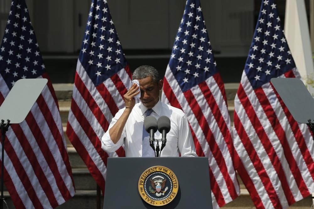 President Barack Obama wipes perspiration from his face as he speaks about climate change at Georgetown University in Washington, Tuesday, June 25, 2013. (Charles Dharapak/AP)