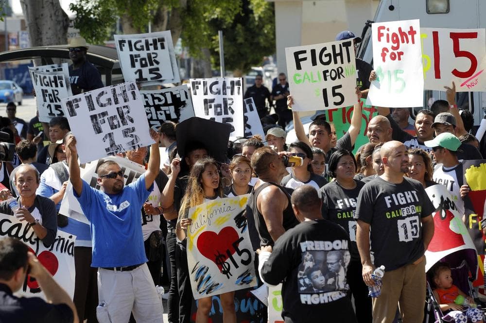 In this Aug. 29, 2013, file photo, protestors demonstrate outside a fast-food restaurant in Los Angeles. Thousands of fast-food workers and their supporters have been staging protests across the country to call attention to the struggles of living on or close to the federal minimum wage. (AP)