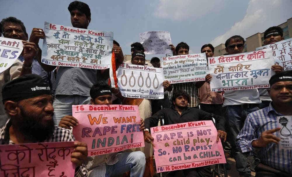 Protestors hold placards outside a court where four men, convicted in the fatal gang rape of a young woman on a moving New Delhi bus last year, are awaiting sentencing, in New Delhi, India, Wednesday, Sept. 11, 2013. (AP Photo/Saurabh Das)