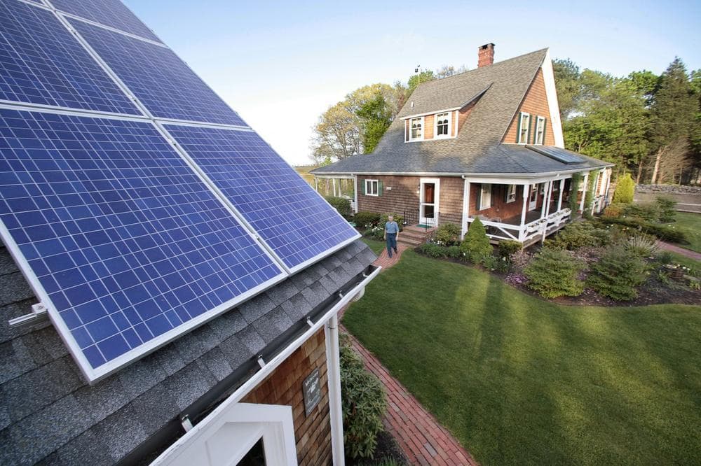 Len Bicknell walks from his house to his garage where his solar energy panels are mounted on the roof in Marshfield, Mass. Bicknell's home is fitted with both thermal panels for hot water production and electric solar panels for energy production. (AP/Stephan Savoia)