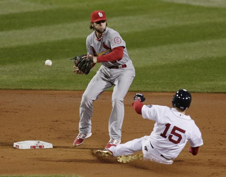 St. Louis Cardinals' Pete Kozma misses the ball as Boston Red Sox's Dustin Pedroia slides into second during the first inning of Game 1 of baseball's World Series Wednesday, Oct. 23, 2013. The second base umpire called Pedroia out, but the call was subsequently overturned. (Charles Krupa/AP)