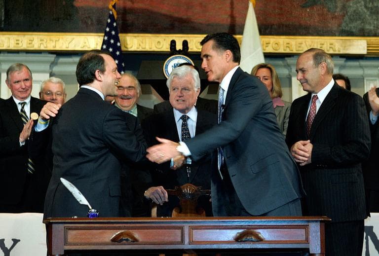 In this April 12, 2006, file photo, then-Gov. Mitt Romney is seen with lawmakers and staffers after signing the state's universal health law at Faneuil Hall in Boston. (AP)