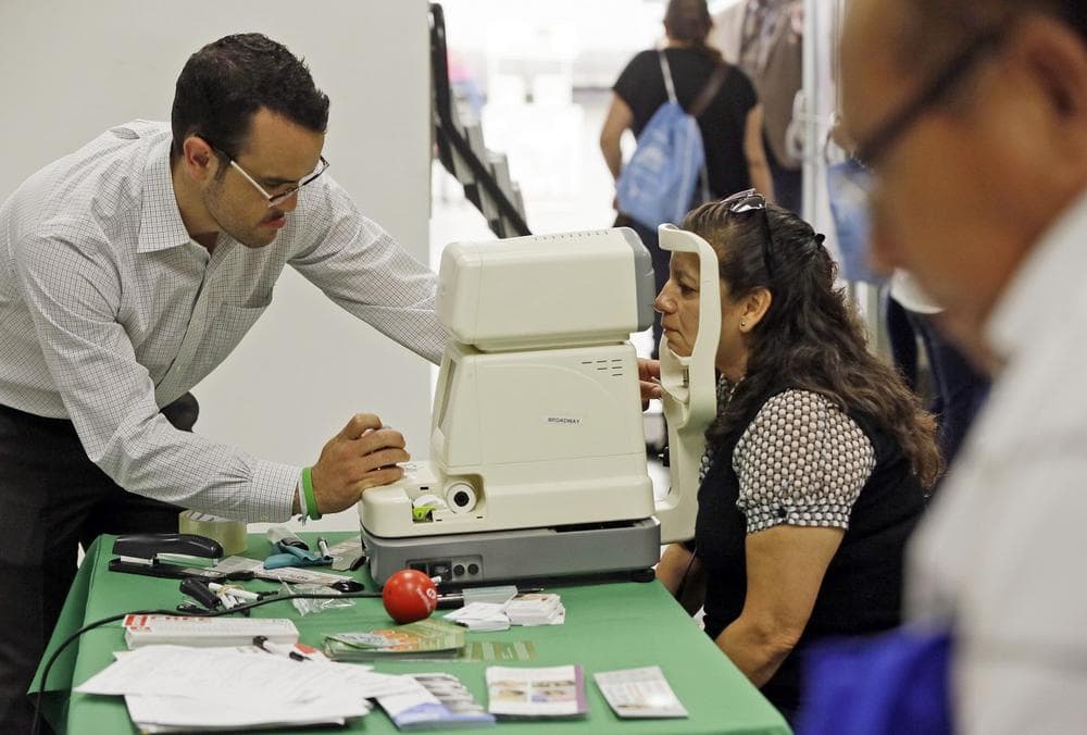 Rosa Guerra, 52, right, gets a free eye exam during the Binational Health Week event held at the Mexican Consulate in Los Angeles Tuesday, Oct. 1, 2013. Tuesday was the first day of the new federal health care law. (AP)