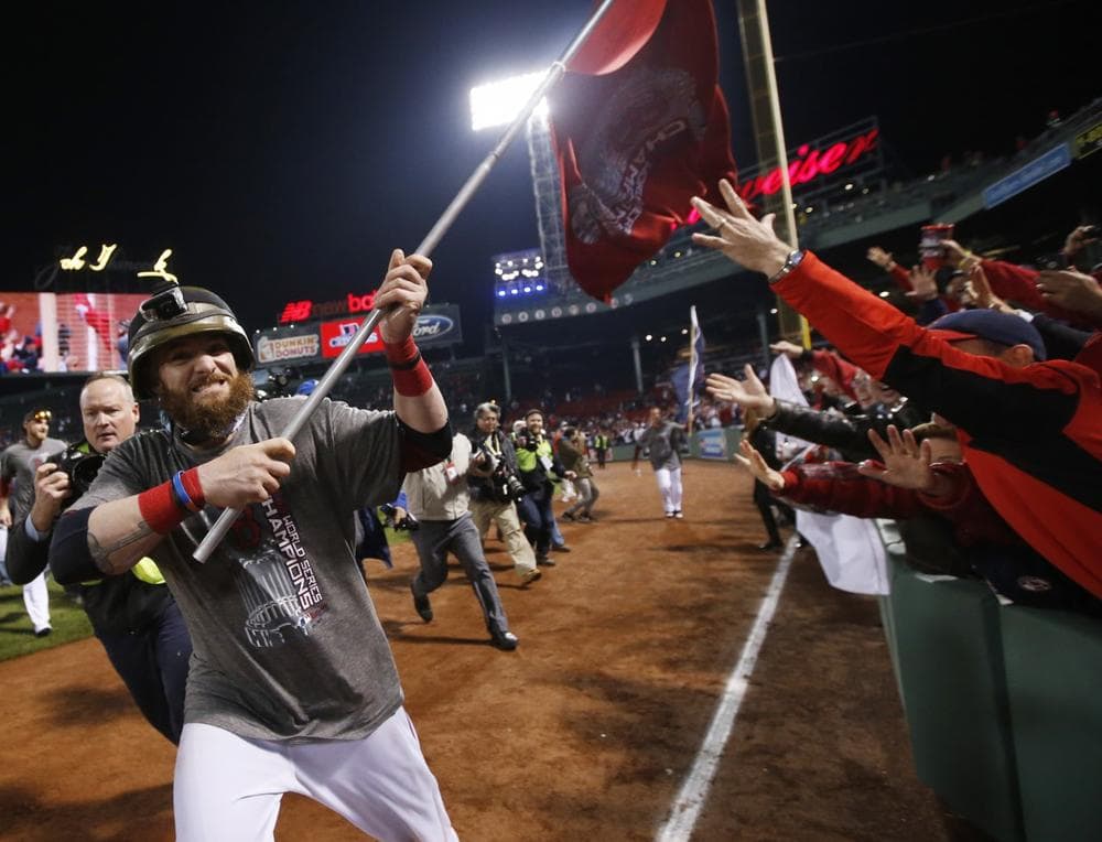 Boston Red Sox left fielder Jonny Gomes runs with a championship flag after defeating the St. Louis Cardinals in Game 6 of baseball's World Series Thursday, Oct. 31, 2013, in Boston. The Red Sox won 6-1 to win the series. (AP Photo/Elise Amendola)