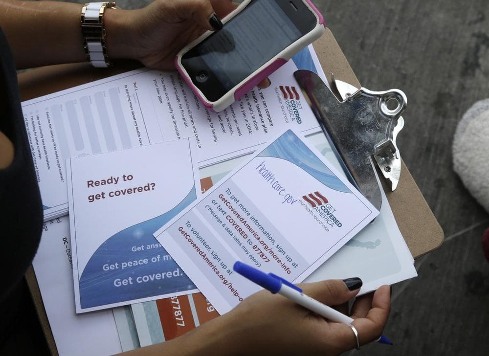 Maygan Rollins, 22, a field organizer with Enroll America, holds a clipboard with pamphlets while canvassing at a bus stop, Wednesday, Sept. 25, 2013, in Miami. (Lynne Sladky/AP)