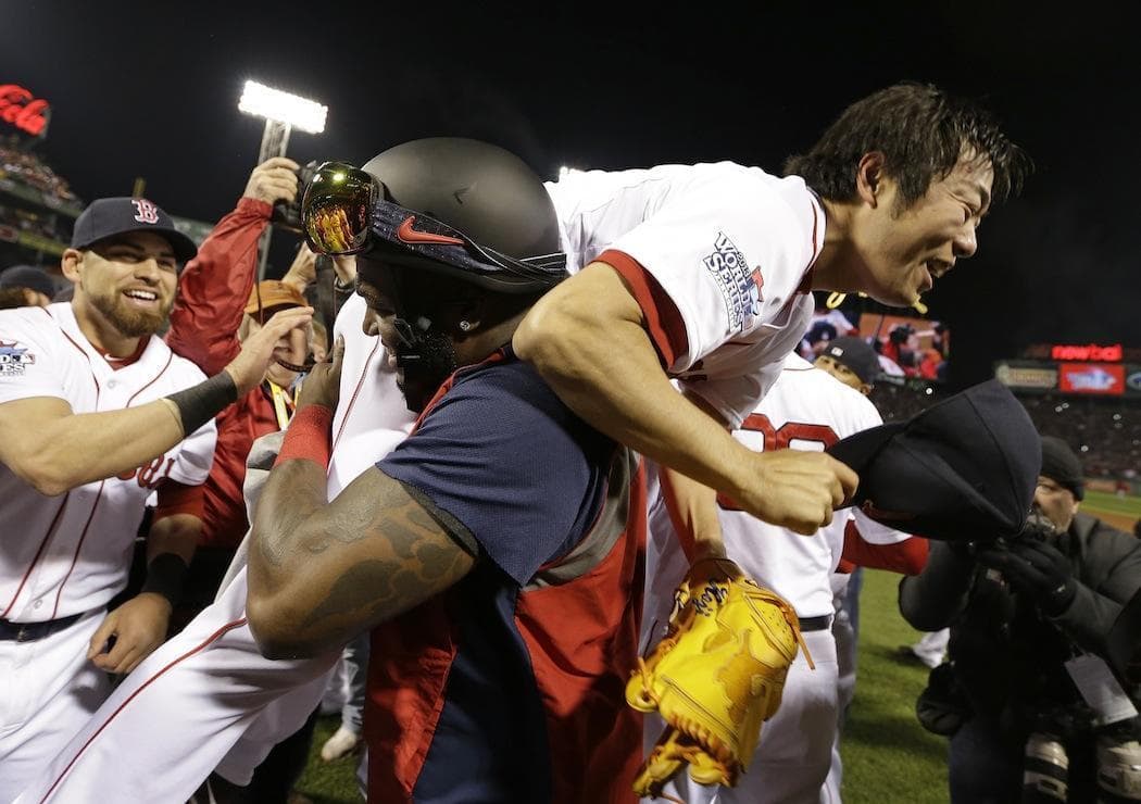 David Ortiz lifts Koji Uehara to celebrate the Red Sox' World Series championship. Jacoby Ellsbury is at the left. (David J. Phillip/AP)