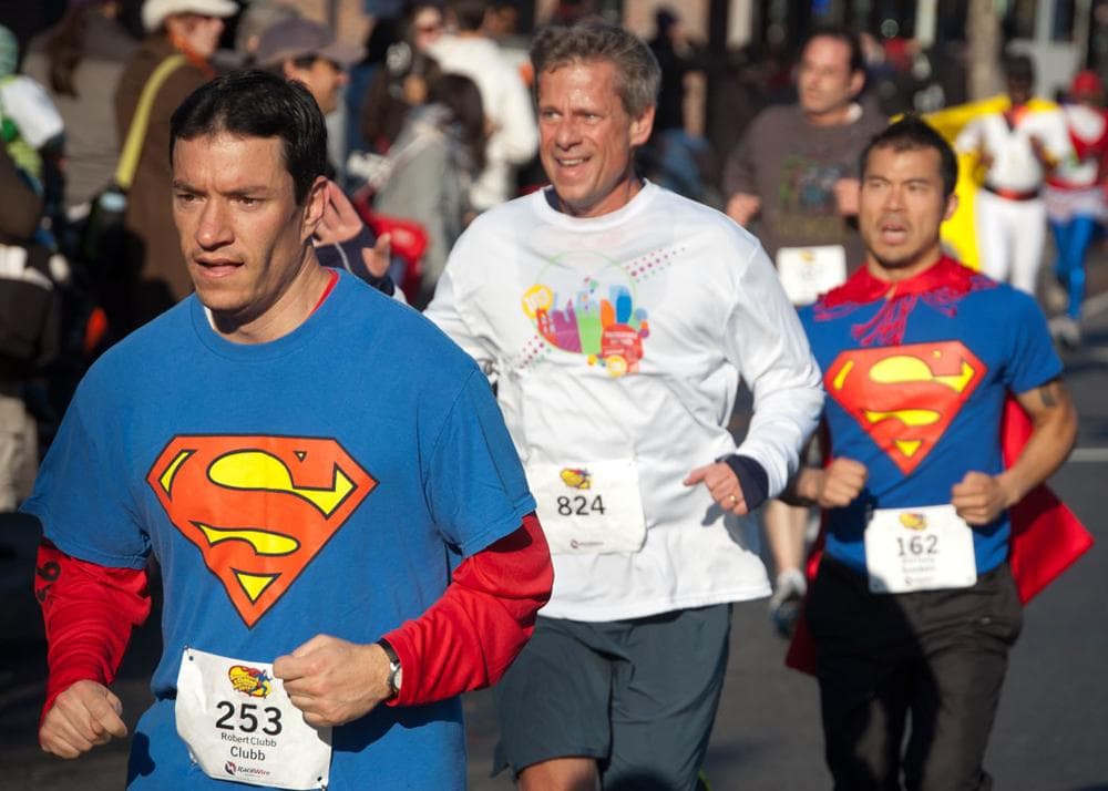 Supermen run along Massachusetts Avenue. (Greg Cook)