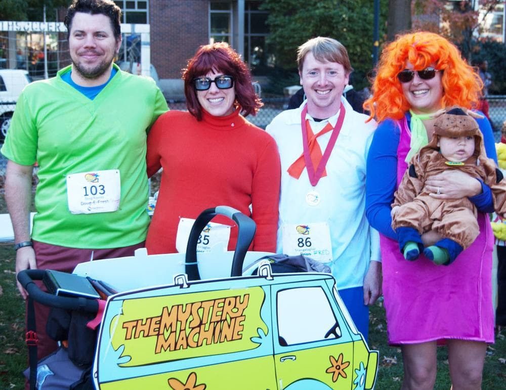 Last year we ran as Ghostbusters. I was the Stay Puft Marshmallow Man,” says Doug Rooney of Watertown (far left). “I was chasing him,” says Tara Pottebaum (far right). At the end of the race, Rooney’s sister waited with a ring—and Rooney asked Pottebaum to marry him. They arrived to this year’s run in Scooby-Doo costumes—including the couple’s five-month old son Orion as Scooby himself. They’re thinking of getting married next year. (Greg Cook)