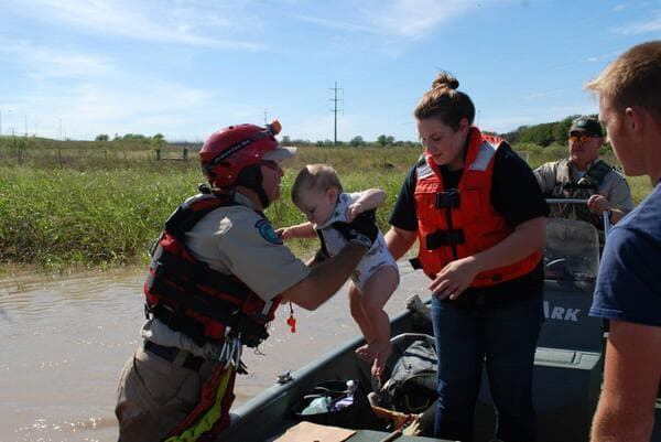 Texas Parks and Wildlife tweeted this picture of a Texas Game Warden rescuing a baby and its mother from the flooding in Austin. (Texas Parks and Wildlife/Twitter)