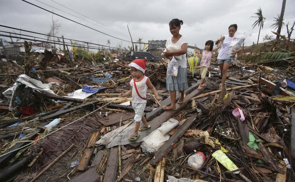 Survivors walk in typhoon-ravaged Tacloban city, Leyte province, central Philippines on Tuesday, Nov. 12, 2013. (Aaron Favila/AP)