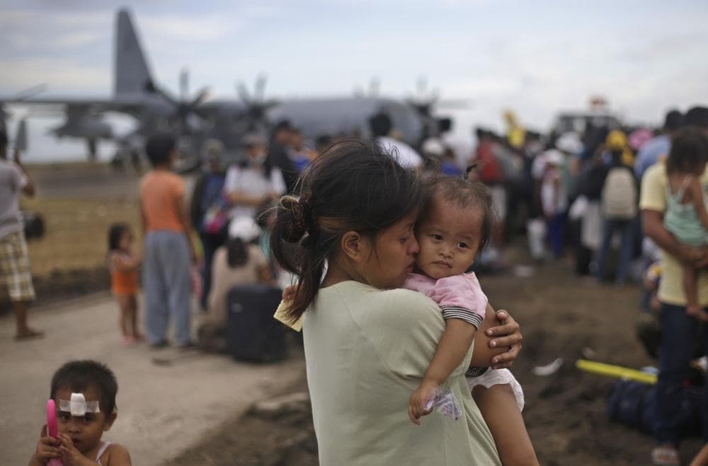 A woman survivor of Typhoon Haiyan weeps as she holds her daughter while waiting for her turn to get on a U.S. Air Force plane to leave for the capital city of Manila, at the airport in Tacloban, central Philippines, Wednesday, Nov. 13, 2013. (Dita Alangkara/AP)