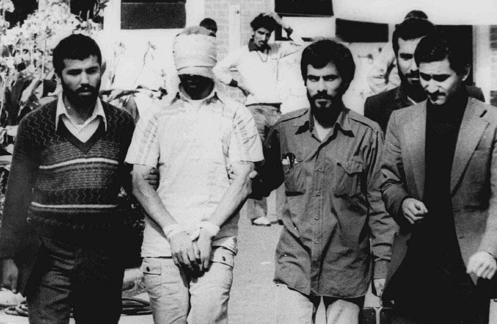 One of the hostages being held at the U.S. Embassy in Tehran is displayed blindfolded and with his hands bound to the crowd outside the embassy, Nov. 9, 1979. Fifty-two of the hostages endured 444 days of captivity. (AP)