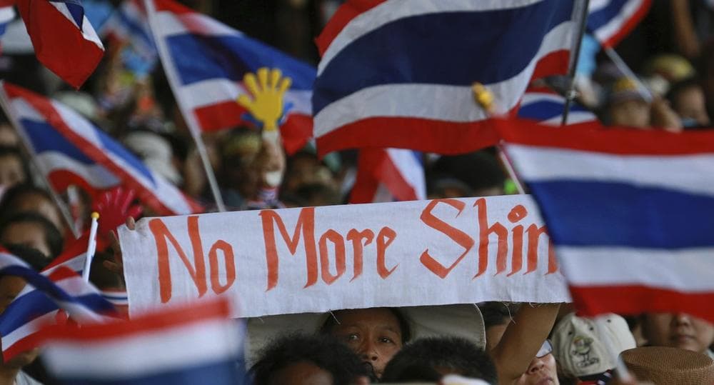 Anti-government protesters wave a banner and Thai national flags as they rally outside the Government complex in Bangkok, Thailand, Wednesday, Nov. 27, 2013. (Wason Wanichakorn/AP)
