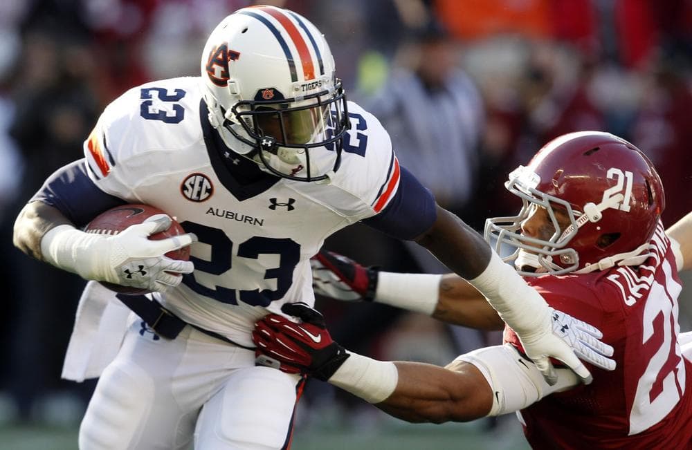 Auburn running back Onterio McCalebb (23) stiff arms Alabama defender Brent Calloway (21) during a kick return during the first half of an NCAA college football game on Saturday, Nov. 24, 2012, in Tuscaloosa, Ala. (Butch Dill/AP)
