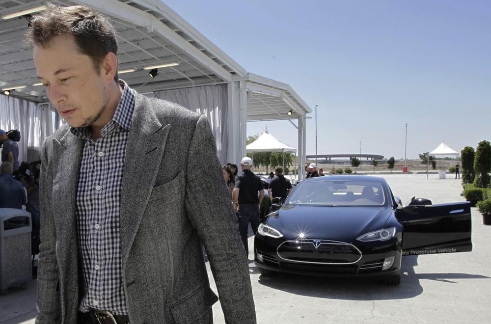 Tesla CEO Elon Musk walks past the Tesla Model S after a news conference at the Tesla factory in Fremont, Calif. (Paul Sakuma/AP)