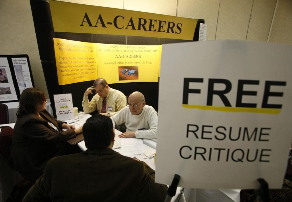 A man helps job seekers with their resumes at a career fair in San Jose, Calif. (Eric Risberg/AP)