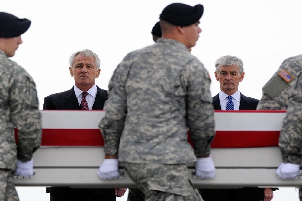 Defense Secretary Chuck Hagel, left, and Army Secretary John McHugh, right, watch an Army carry team move a transfer case containing the remains of Pfc. Cody J. Patterson Wednesday, Oct. 9, 2013 at Dover Air Force Base, Del. (AP)
