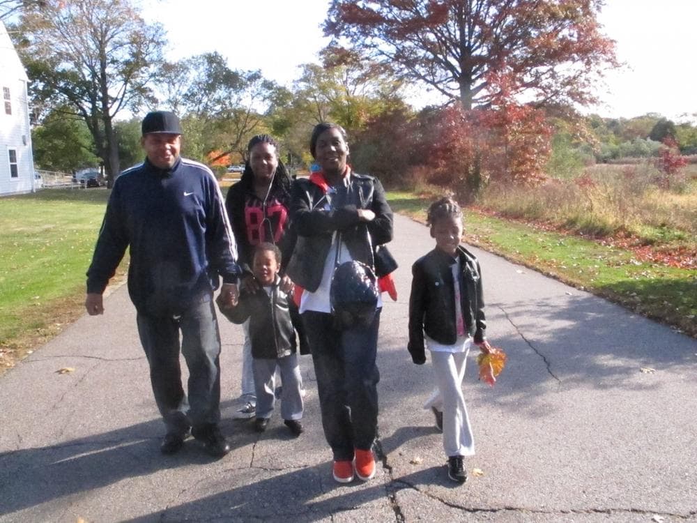 Melody Salhudin (right) leads her family on a walk through Cushing Park in Framingham (Martha Bebinger/WBUR)