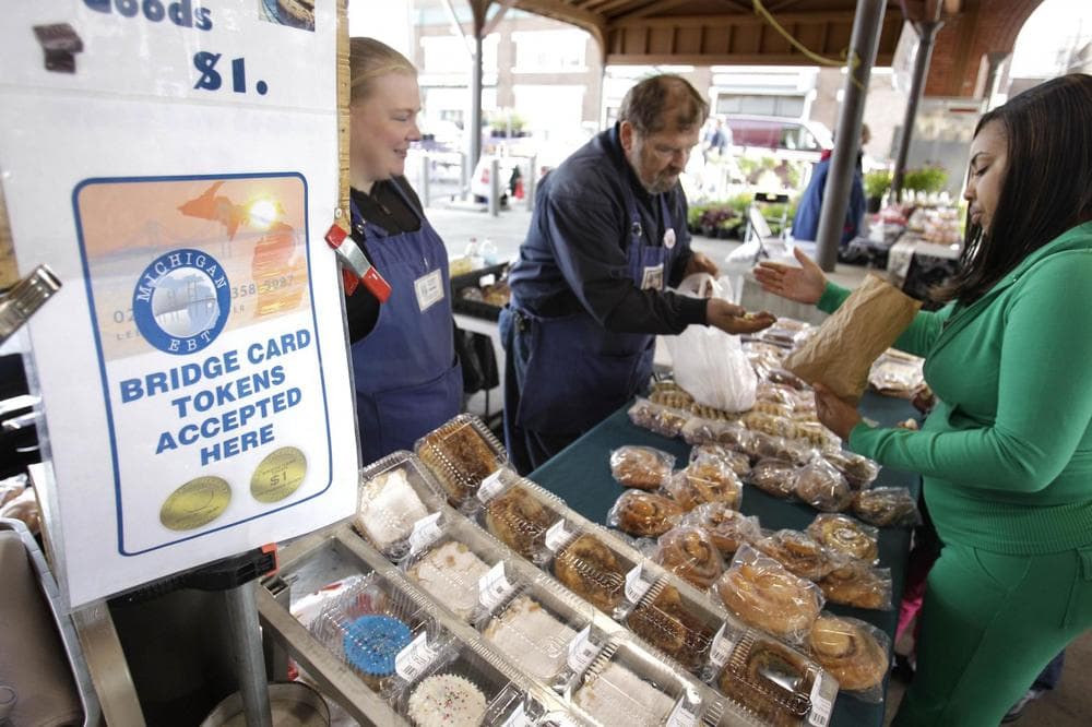 In this Sept. 11, 2010 file photo, Temeka Williams, right, of Detroit, uses her EBT/Bridge Card tokens for a purchase from Elizabeth and Gary Lauber from Sweet Delights at the Farmer's Market in Detroit. The temporary increase in food stamps also know as the Supplemental Nutrition Assistance Program expires Oct. 31, meaning for millions of Americans, the benefits that help them put food on the table every month won’t stretch as far as they have for the past four years. (AP)