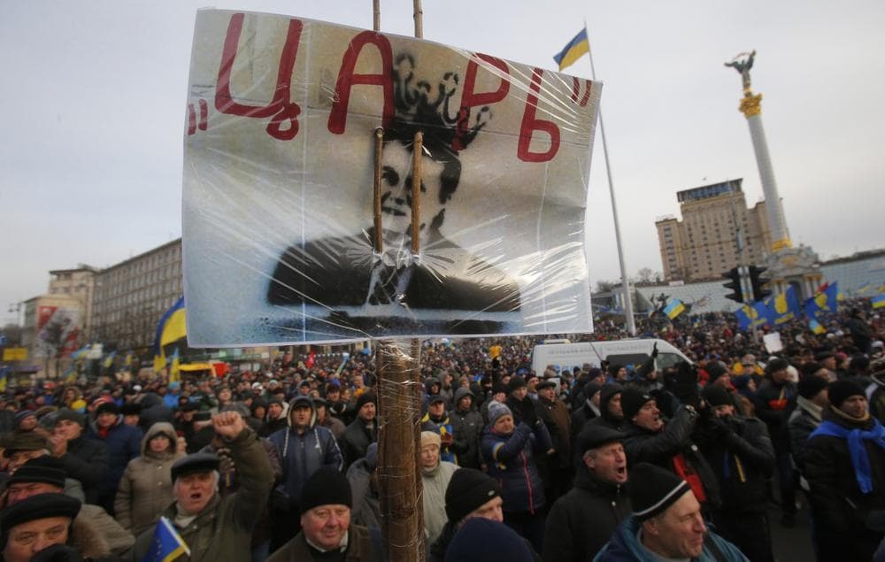 Protesters hold a placard with a portrait of President Viktor Yanukovych and reading &quot;Tsar&quot; as they rally at the central Independence square in Kiev, Ukraine, on Tuesday, Dec. 3, 2013. (Sergei Grits/AP)