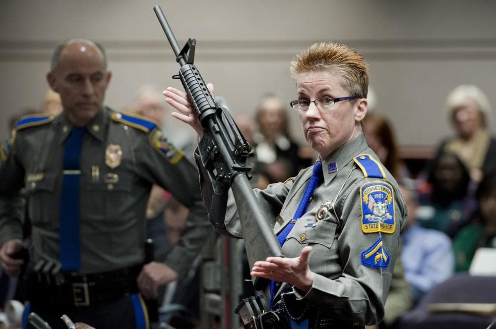 Firearms Training Unit Detective Barbara J. Mattson of the Connecticut State Police holds up a Bushmaster AR-15 rifle, the same gun used by Adam Lanza in the Sandy Hook School shooting, for a demonstration during a hearing of a legislative subcommittee reviewing gun laws, at the Legislative Office Building in Hartford, Conn., Monday, Jan. 28, 2013. (Jessica Hill/AP)