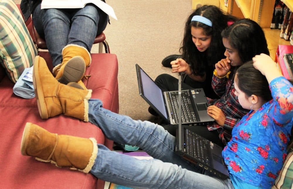 Students work on laptops in the library. (Enokson/Flickr)