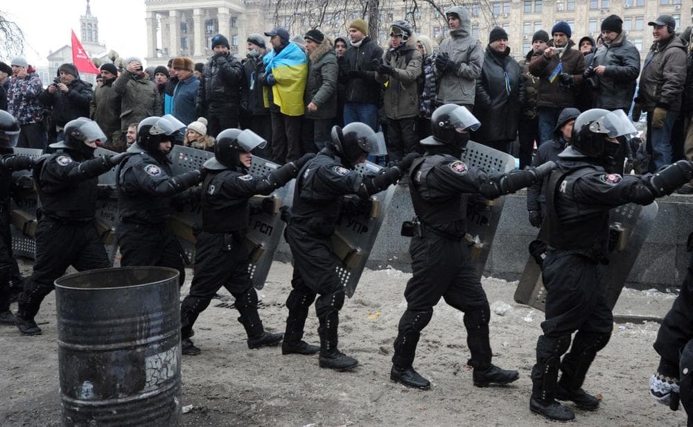 Anti-riot police draw up in front of anti-Yanukovych protesters on Independence Square in Kiev, on December 11, 2013. Ukrainian security forces pulled out of the epicentre of mass protests in Kiev today after a nine hour standoff with thousands of demonstrators, in a major boost for the opposition to President Viktor Yanukovych. (Viktor Drachev/AFP/Getty Images)