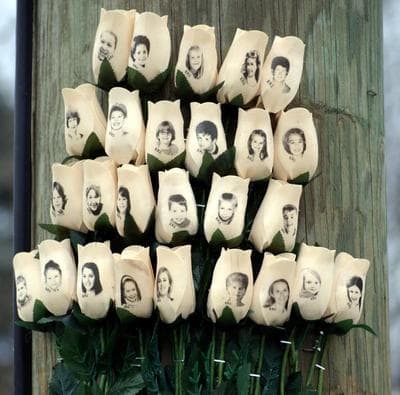 A Newtown memorial in the form of carved wooden roses, with faces imprinted, attached to a telephone pole. (Robert Carley)