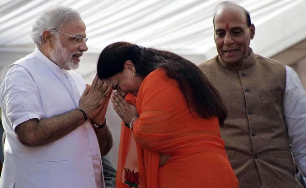 India’s main opposition Bharatiya Janata Party (BJP) leader Vasundhara Raje, center, greets party prime ministerial candidate and chief minister of Gujarat state Narendra Modi, left, and party president Rajnath Singh before her oath taking ceremony as the chief minister of Rajasthan state in Jaipur, India, Friday, Dec. 13, 2013. (Deepak Sharma/AP Photo)