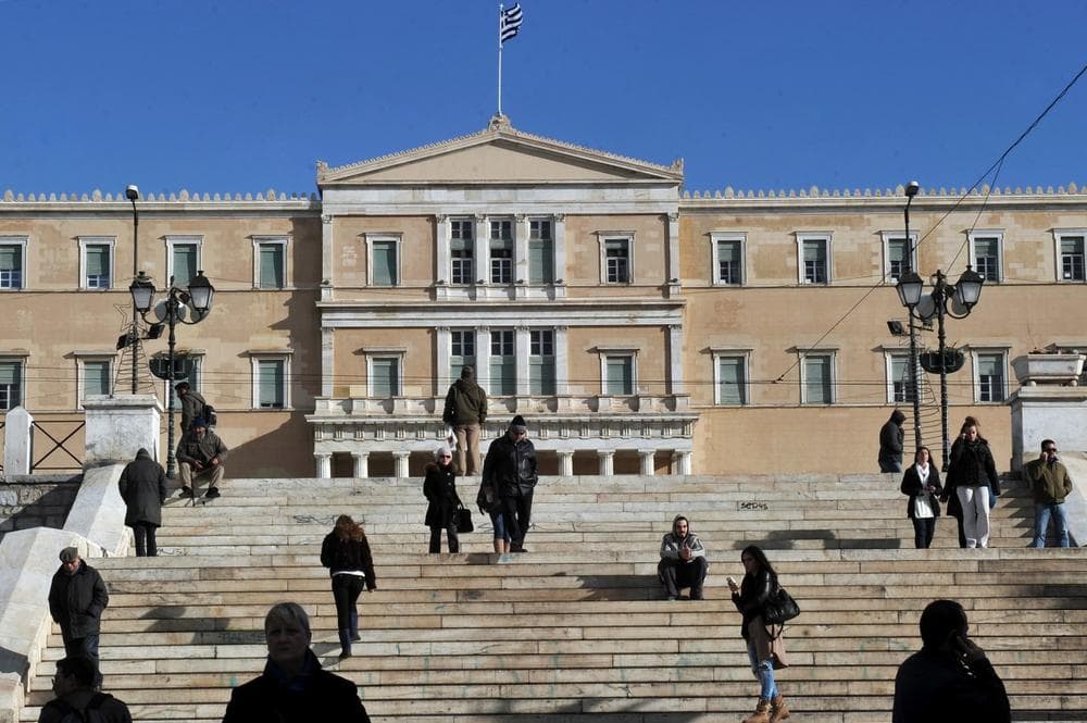 People walk in front of the Greek parliament in Athens on December 11, 2013. Greece is facing a sixth year of recession and unemployment reached 27.4 percent in September up from 26 percent in the same month last year. (Louisa Gouliamaki/AFP/Getty Images)
