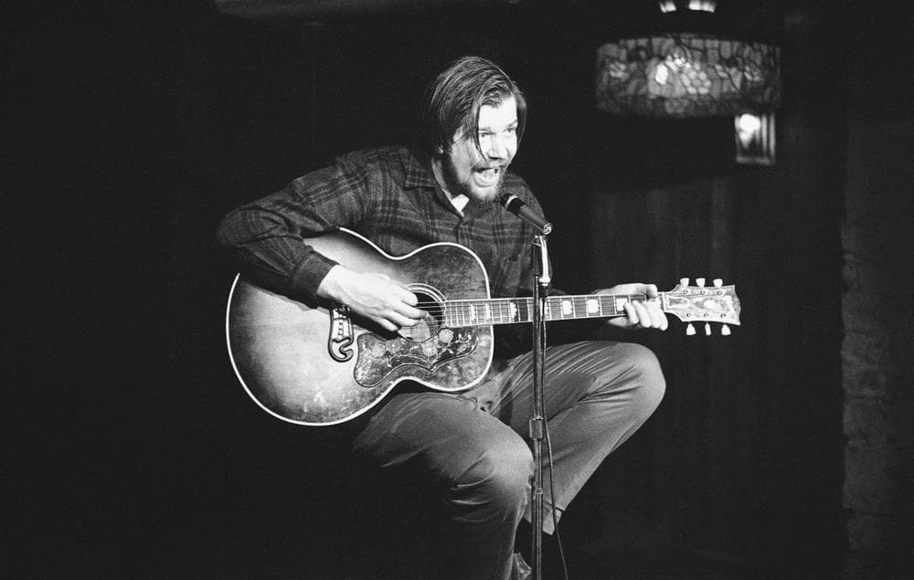 Armed with guitar, mike and enthusiasm, folk singer Dave Van Ronk performs at the Gaslight coffee house in New York's Greenwich Village on Nov. 8, 1963. (AP)