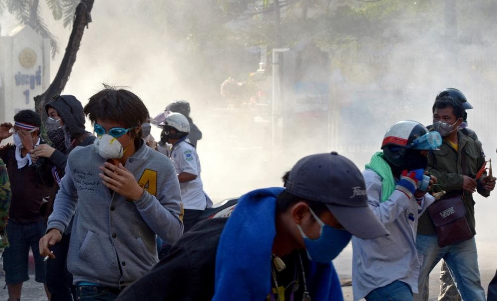 Thai anti-government protesters run from tear gas during a rally at a stadium to register party-list candidates in Bangkok. (AFP/Getty Images)